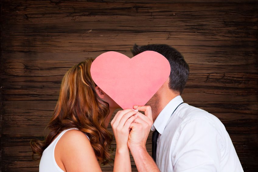 26055614 - cute kissing couple on wooden background
