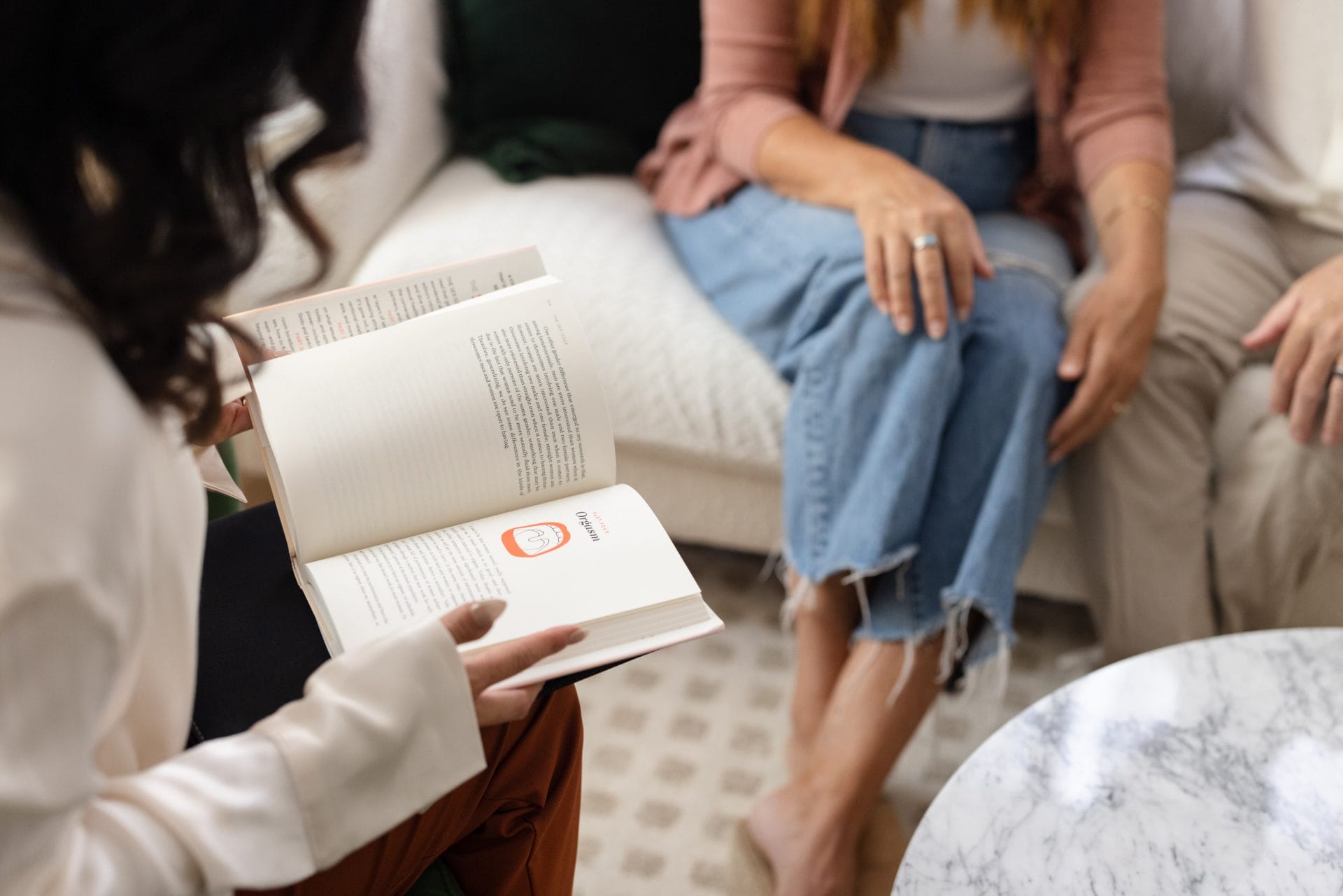 Hands holding a book with people in the background