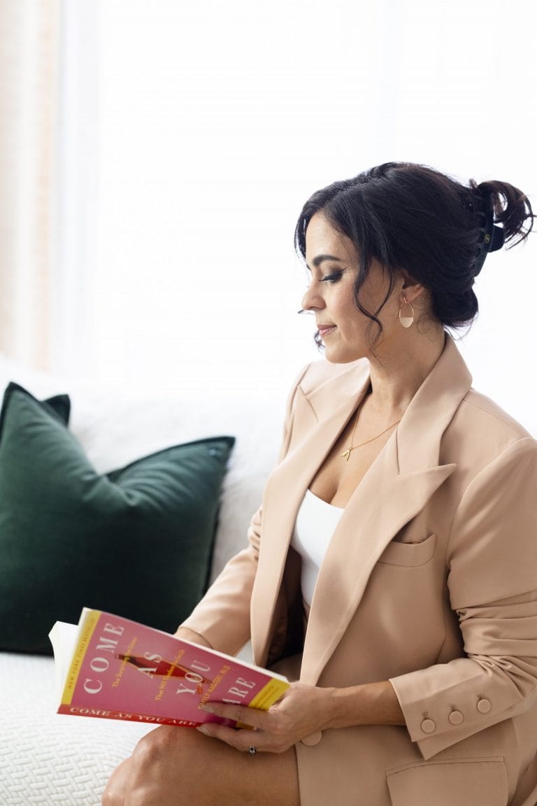 Dr. Shannon Chavez sitting on a sofa reading a magazine.