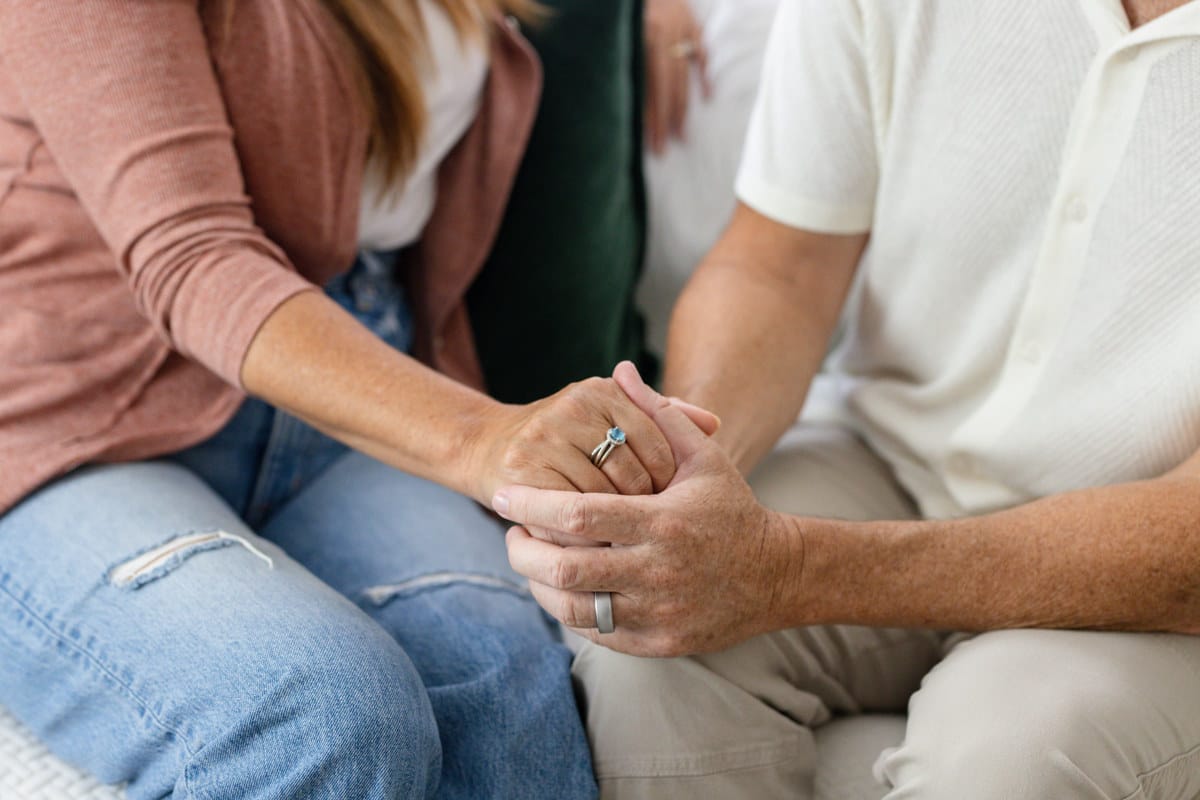 A couple, married, holding hands with wedding bands.