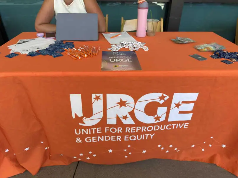 URGE (Unite for Reproductive & Gender Equity) resource table at the Black Women for Wellness Annual Reproductive Justice Conference, displaying materials on reproductive justice, gender equity, and youth leadership.