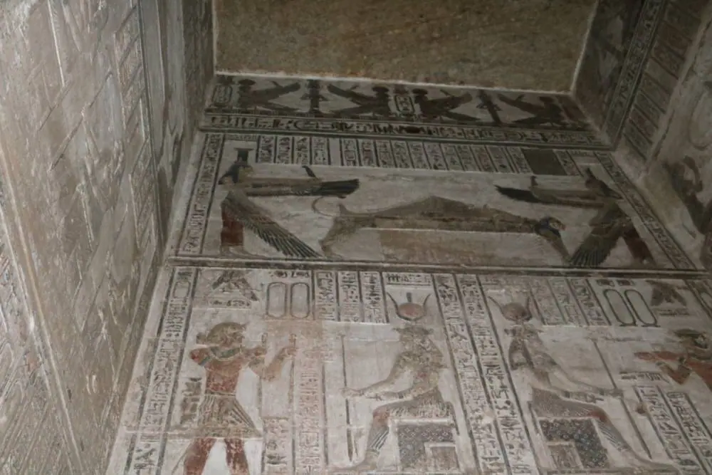 Tomb relief showing Osiris on the funerary bier with Isis and Nephthys, symbolizing resurrection and eternal life.