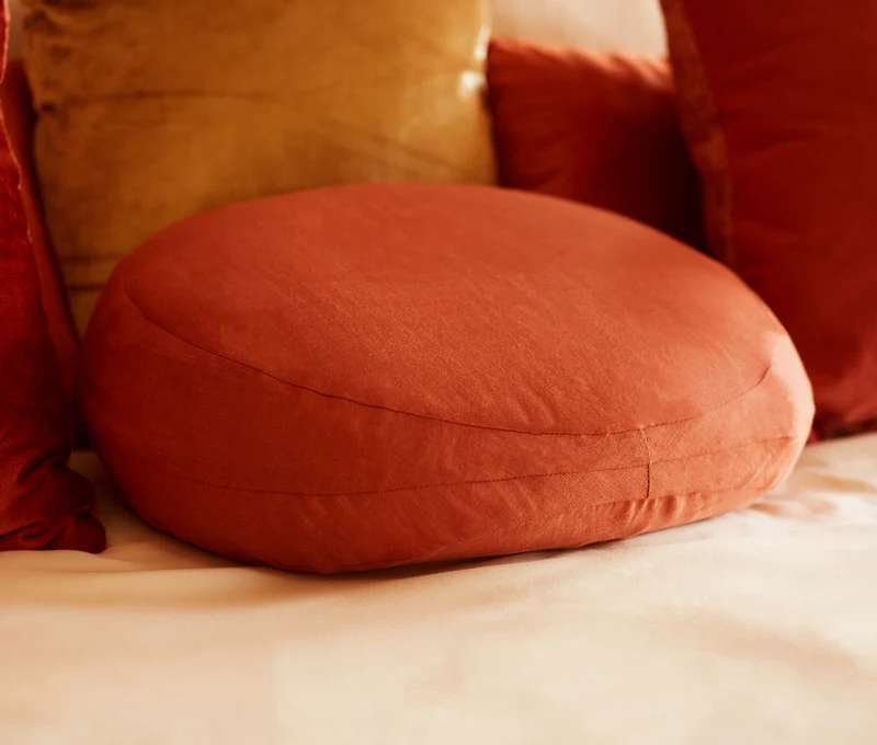 A soft, sculpted Tabu Pillow “The Prim” designed for intimate comfort and support on a bed.