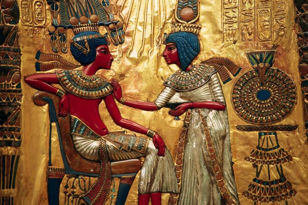 Golden throne relief showing Pharaoh Tutankhamun and Queen Ankhesenamun in an intimate scene, symbolizing royal love, harmony, and divine blessing in ancient Egypt.